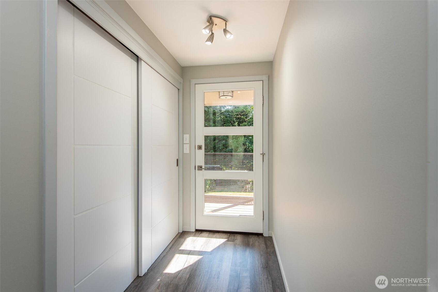 681 Bachelor Road Sequim, WA 98382 - Photo 6 of 39 a view of a hallway with wooden floor and a window