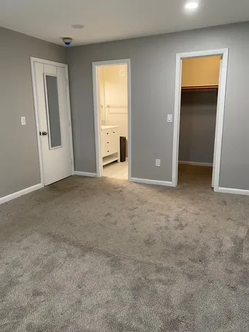 an empty room with windows & cabinet