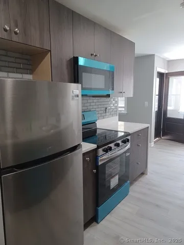 a kitchen with stainless steel appliances and a refrigerator