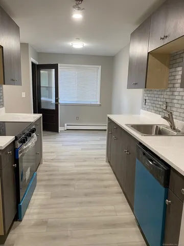 a kitchen with granite countertop a sink and a stove top oven