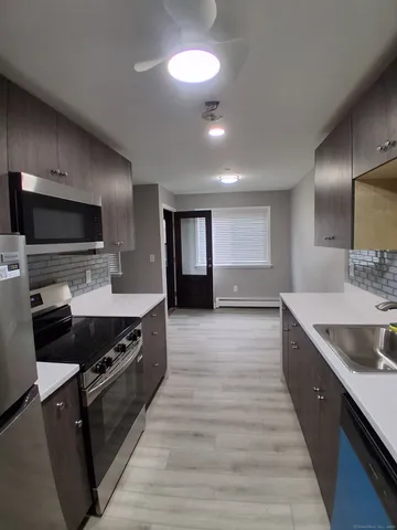 a large kitchen with stainless steel appliances granite countertop a stove a sink and a granite counter tops