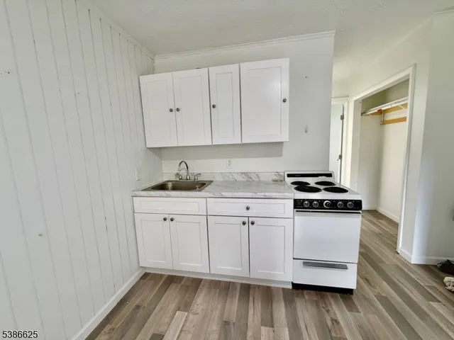 a kitchen with granite countertop white cabinets and white appliances