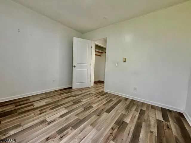 a view of a room with wooden floor and white walls
