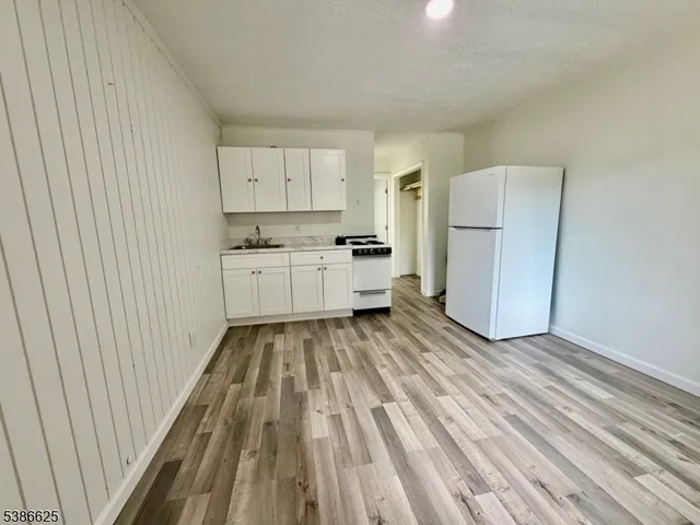 a kitchen with a refrigerator and white cabinets