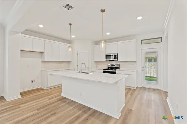 a kitchen with stainless steel appliances a sink a stove and microwave