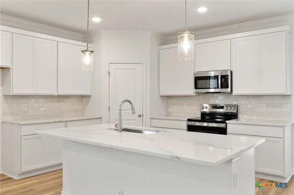 a kitchen with white cabinets stainless steel appliances and sink