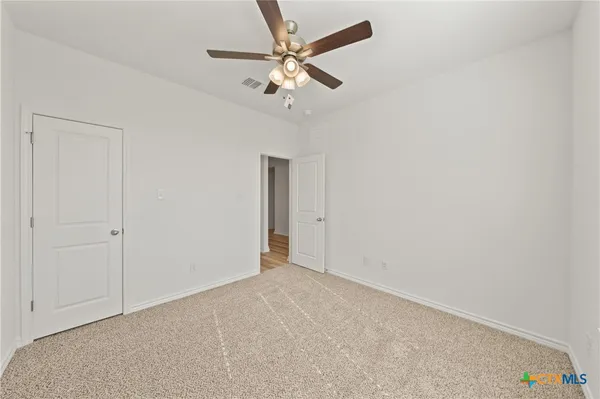 a view of empty room with wooden floor and window
