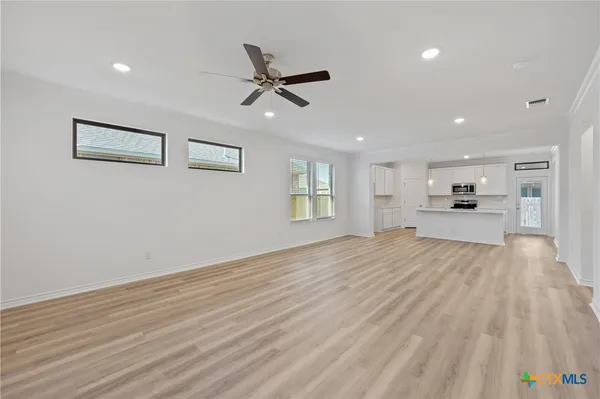 a view of empty room with wooden floor