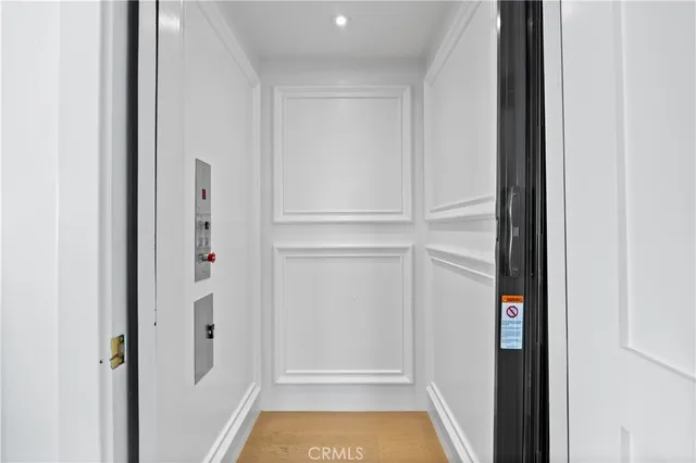 a living room with furniture large window and kitchen view