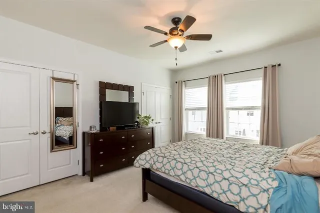 a bedroom with a bed and a flat tv screen on dresser