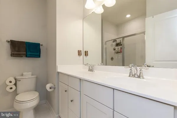 a bathroom with a sink a toilet a mirror and shower