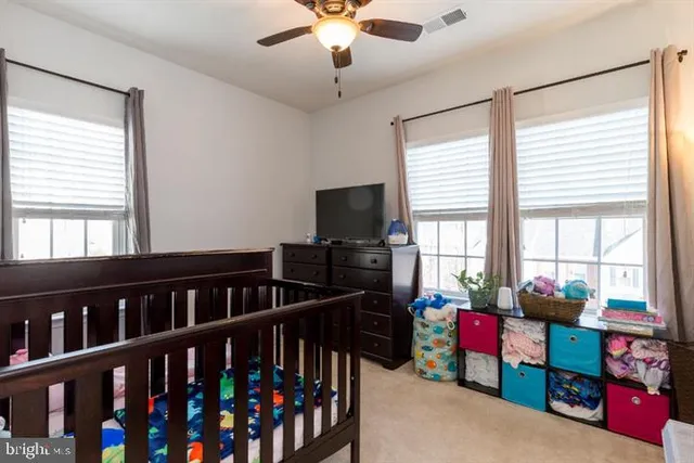 a bedroom with furniture a flat screen tv and a window