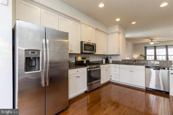 a kitchen with a refrigerator a sink and a stove top oven