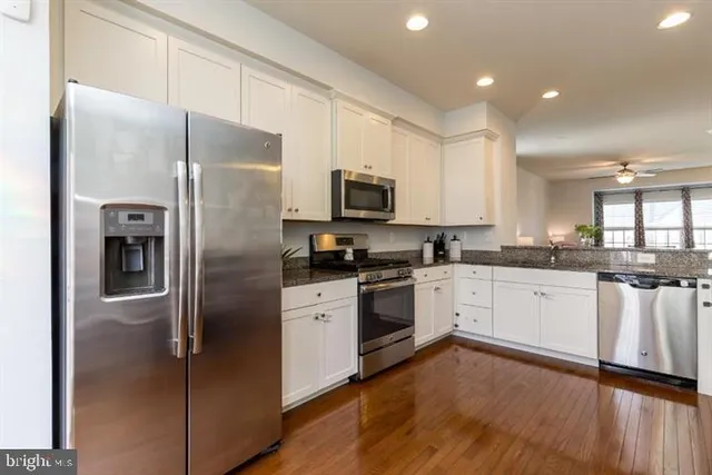a kitchen with a refrigerator a sink and a stove top oven