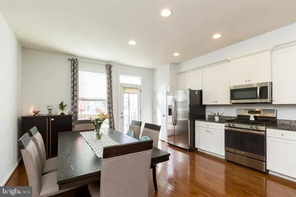 a living room with stainless steel appliances furniture a flat screen tv and large window