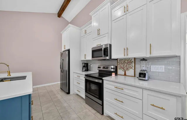 a kitchen with white cabinets and stainless steel appliances