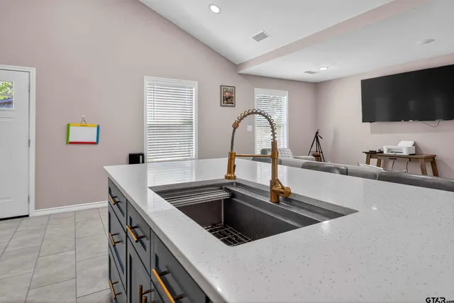 a kitchen with granite countertop a sink and a stove top oven with wooden floor