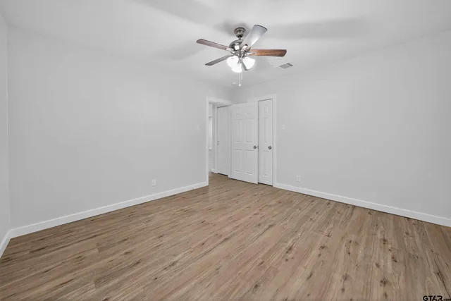 a view of an empty room with wooden floor
