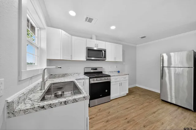 a kitchen with a stove a sink and a refrigerator