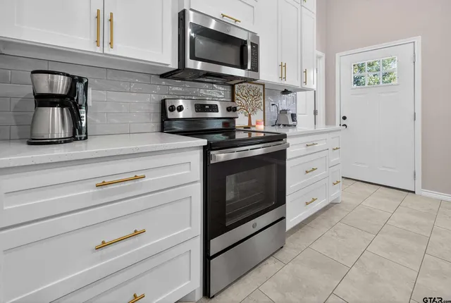 a kitchen with stainless steel appliances granite countertop a stove and a microwave