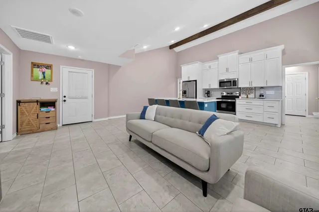 a living room with furniture and a refrigerator