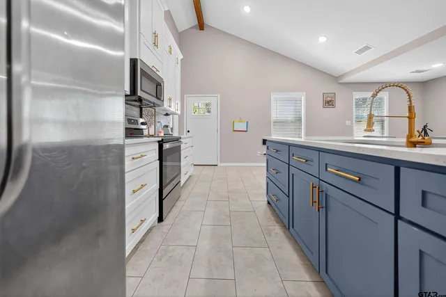 a large kitchen with stainless steel appliances lots of counter space and a sink