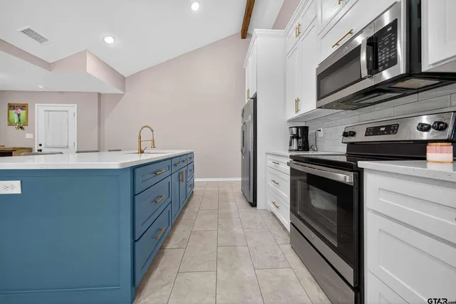 a kitchen with stainless steel appliances granite countertop a stove a sink and a microwave