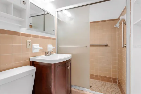a bathroom with a sink a toilet and shower