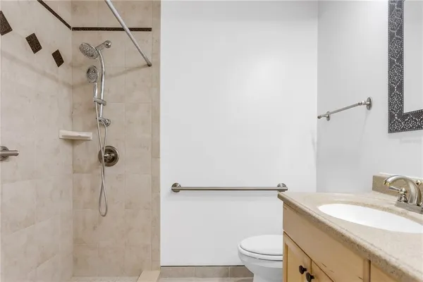 a bathroom with a granite countertop sink toilet and shower