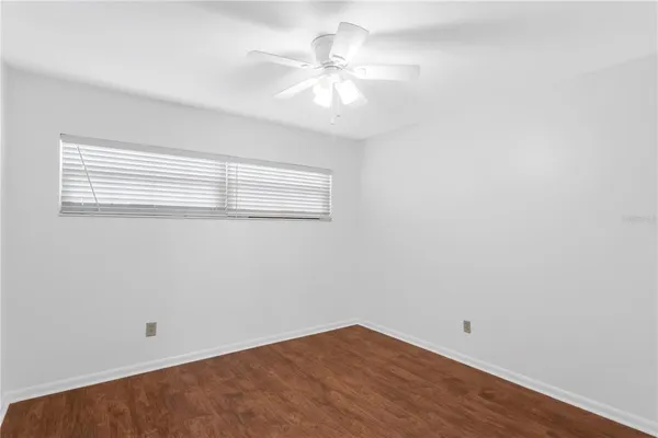 an empty room with a window and a fan