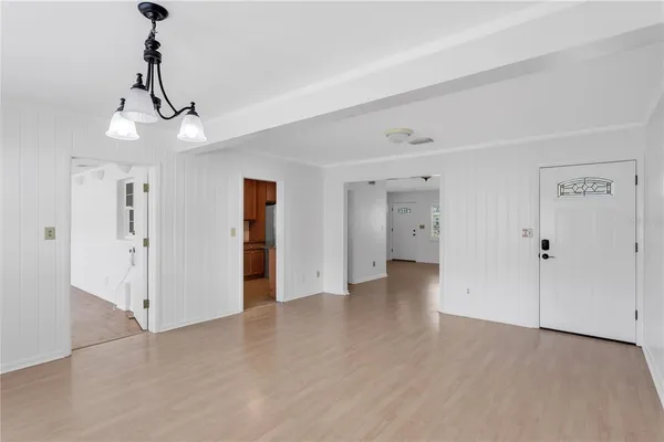 a view of an empty room with wooden floor and windows