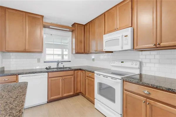 a kitchen with stainless steel appliances granite countertop a sink stove and cabinets