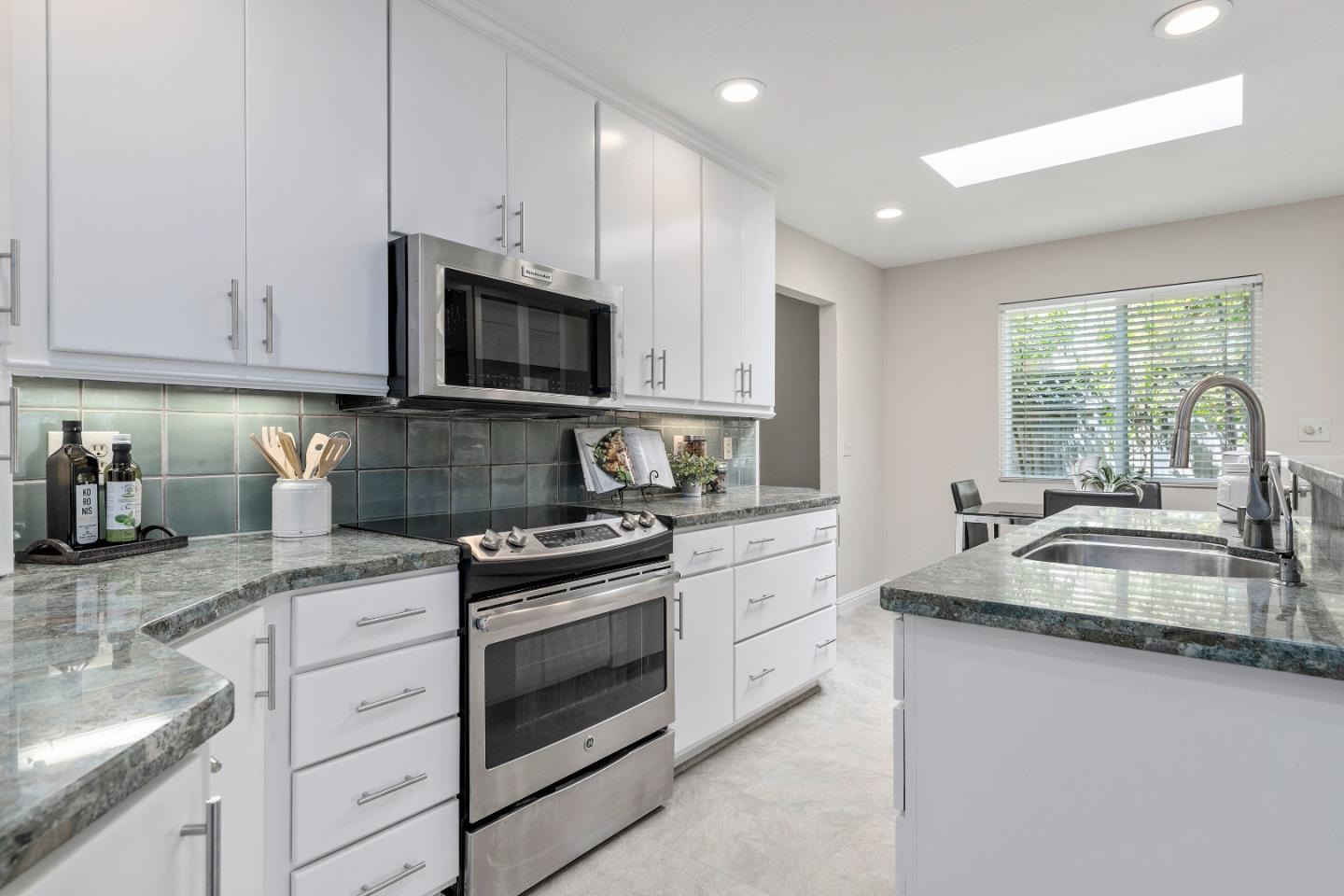 20044 Pacifica Drive Cupertino, CA 95014 - Photo 7 of 23 a kitchen with granite countertop a sink stove and cabinets