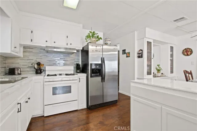 a kitchen with stainless steel appliances white cabinets and a refrigerator