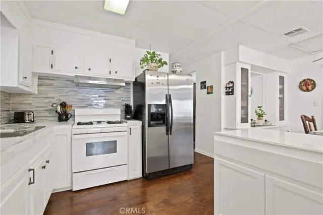 a kitchen with stainless steel appliances white cabinets and a refrigerator