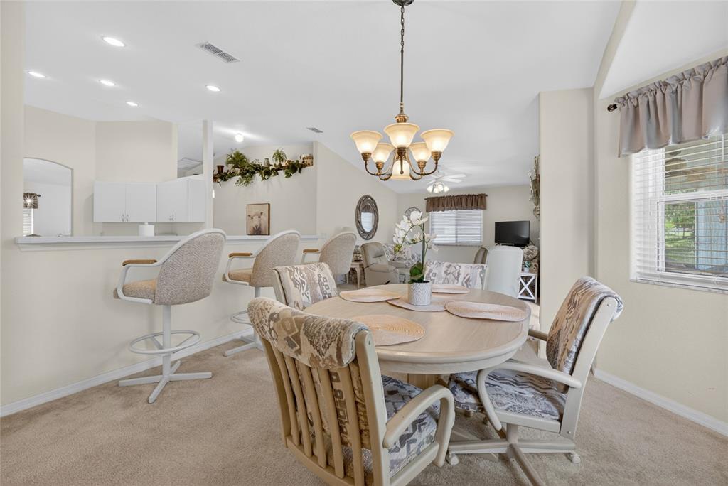 6032 Southwest 103rd Loop Ocala, FL 34476 - Photo 7 of 28 a view of a dining room with furniture a chandelier and wooden floor