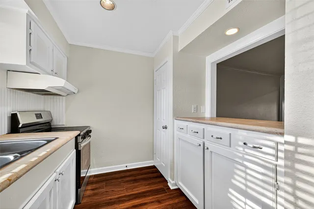 a view of a kitchen with cabinets and wooden floor