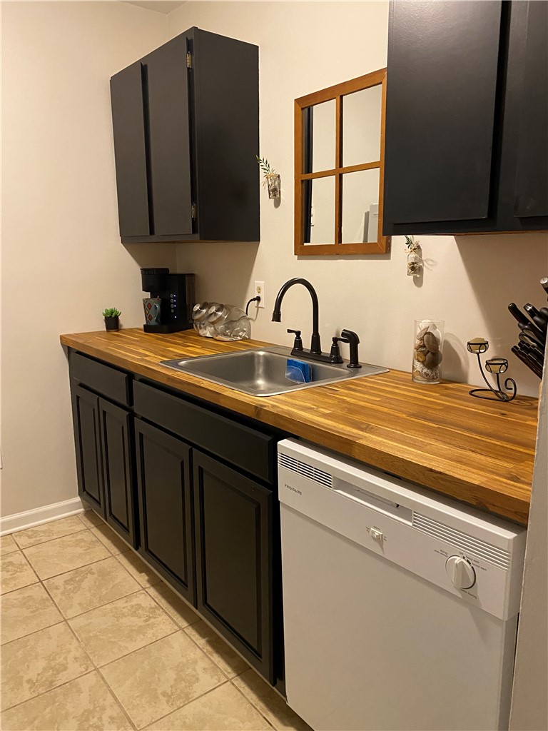 125 Maple Street, Unit 110 Pendleton, SC 29670 - Photo 9 of 22 Well-appointed kitchen featuring sleek dark cabinetry and warm wood countertops.