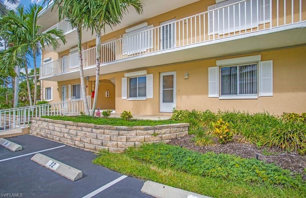 3012 Sandpiper Bay Circle, Unit D102 Naples, FL 34112 - Photo 1 of 13 a front view of a house with a garden
