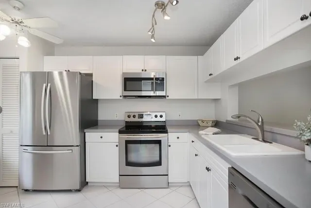 a kitchen with stainless steel appliances a refrigerator sink and microwave