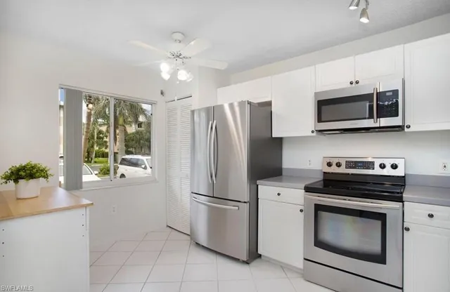 a kitchen with stainless steel appliances white cabinets and a stove top oven