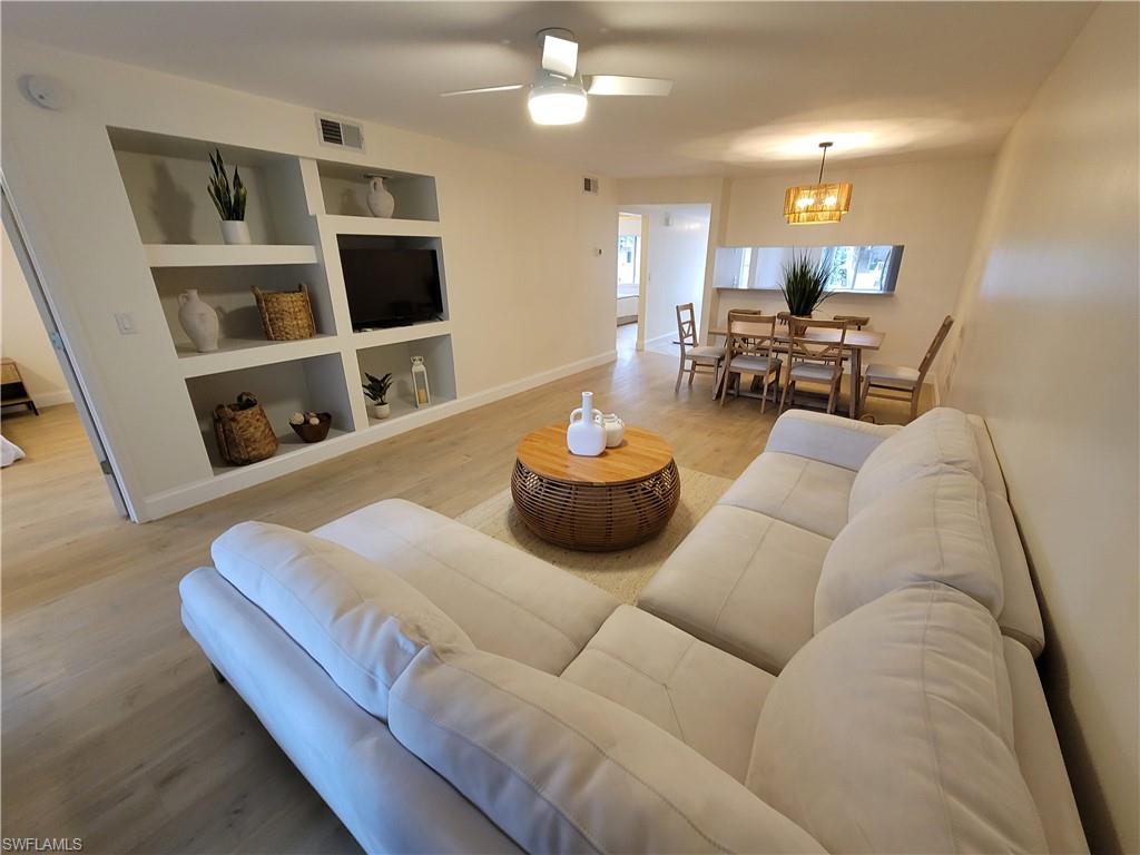 3012 Sandpiper Bay Circle, Unit D102 Naples, FL 34112 - Photo 5 of 13 a living room with furniture and a flat screen tv