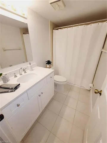 a spacious bathroom with a double vanity sink toilet and a mirror