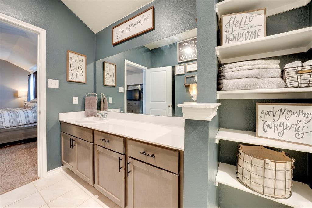 830 Rustic Way Josephine, TX 75189 - Photo 22 of 33 Bathroom with connected bathroom, lofted ceiling, vanity, tile patterned flooring, and a textured wall