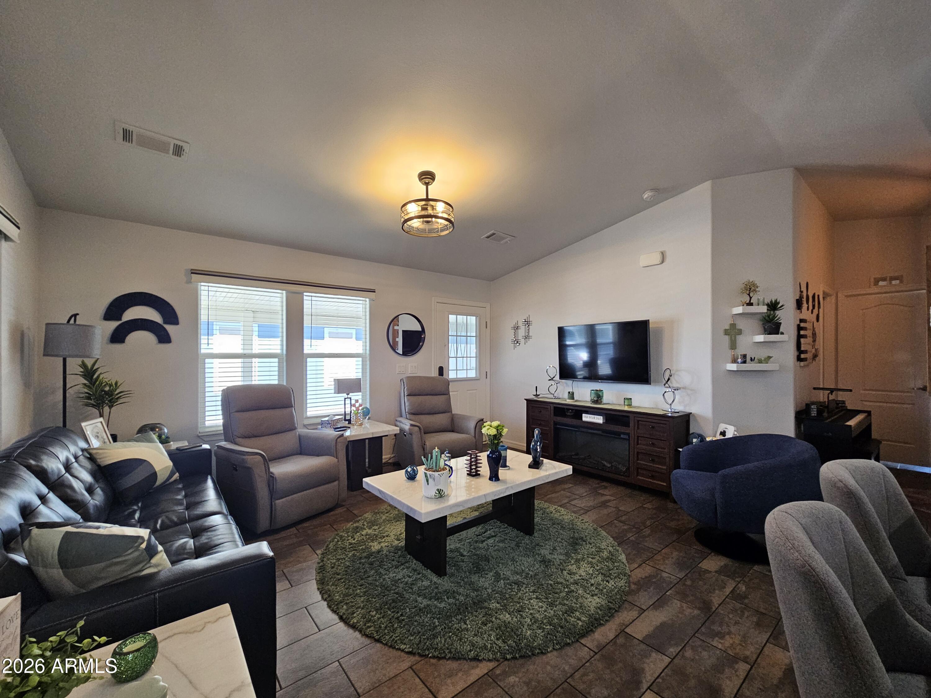 650 North Hawes Road, Unit 3406 Mesa, AZ 85207 - Photo 12 of 45 a living room with furniture a fireplace and a flat screen tv