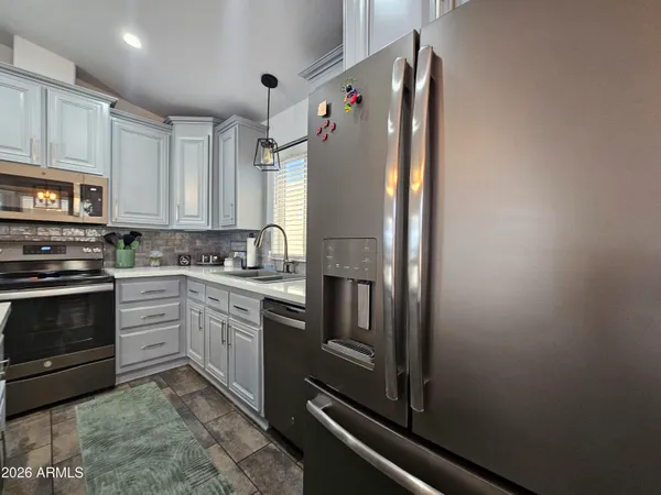 a kitchen with stainless steel appliances granite countertop a sink a stove and cabinets
