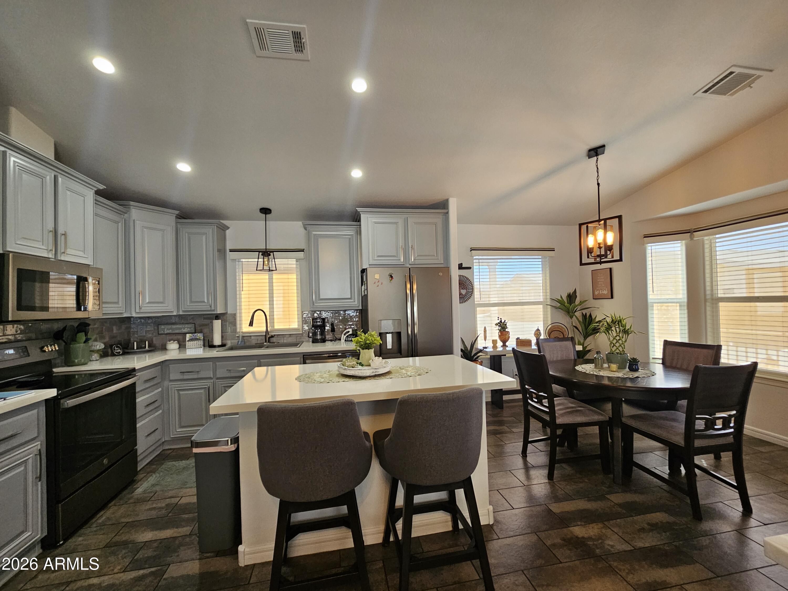 650 North Hawes Road, Unit 3406 Mesa, AZ 85207 - Photo 19 of 45 a kitchen with stainless steel appliances granite countertop a sink a stove a dining table and chairs