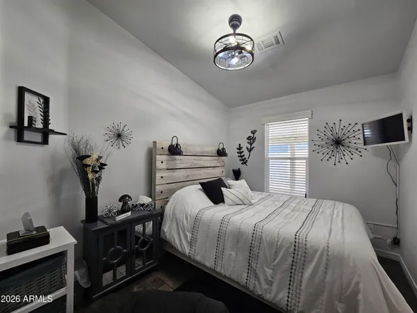 a bedroom with a bed and a flat tv screen on the dresser