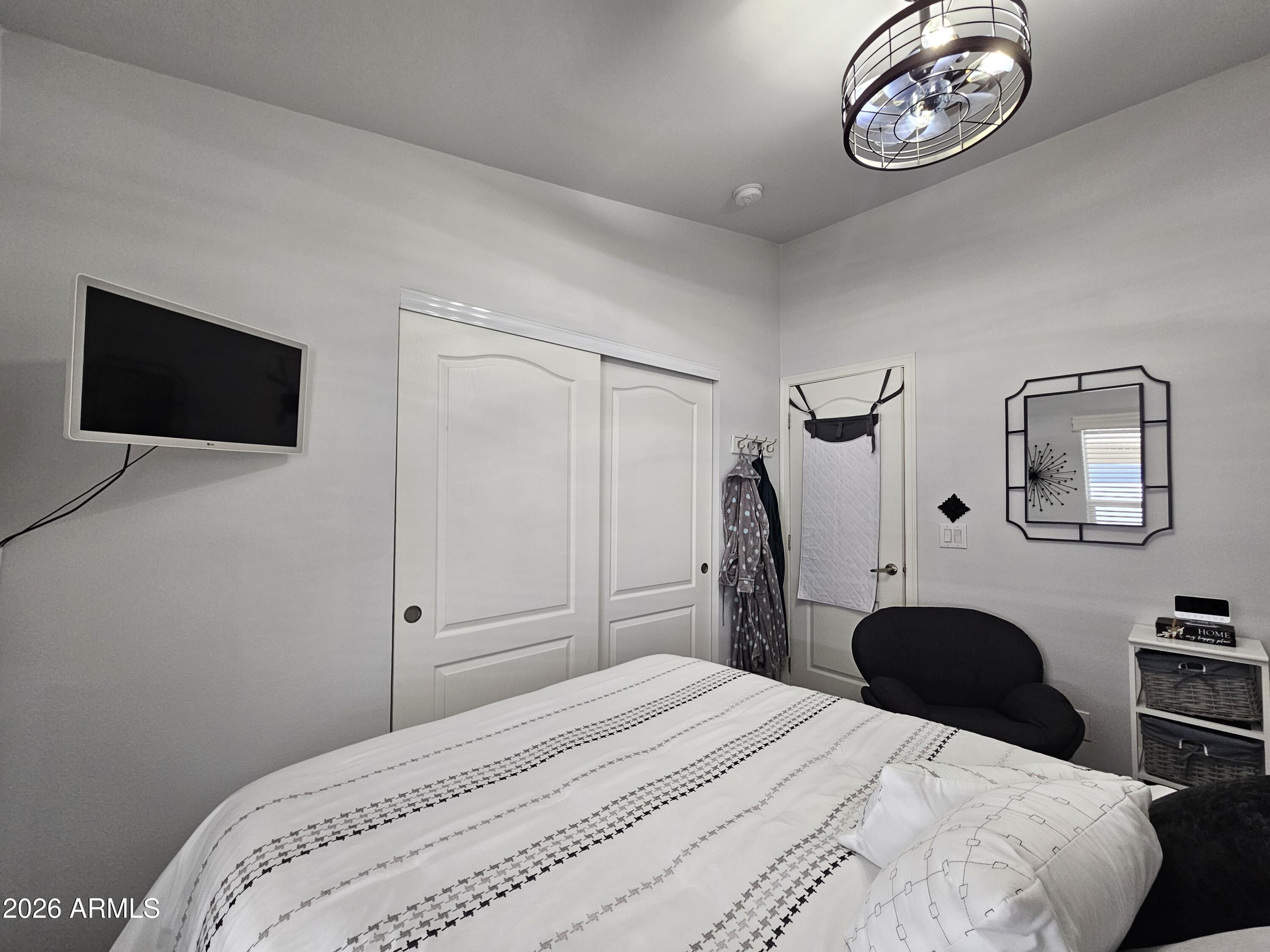 650 North Hawes Road, Unit 3406 Mesa, AZ 85207 - Photo 23 of 45 a bedroom with a bed and a flat tv screen on the dresser