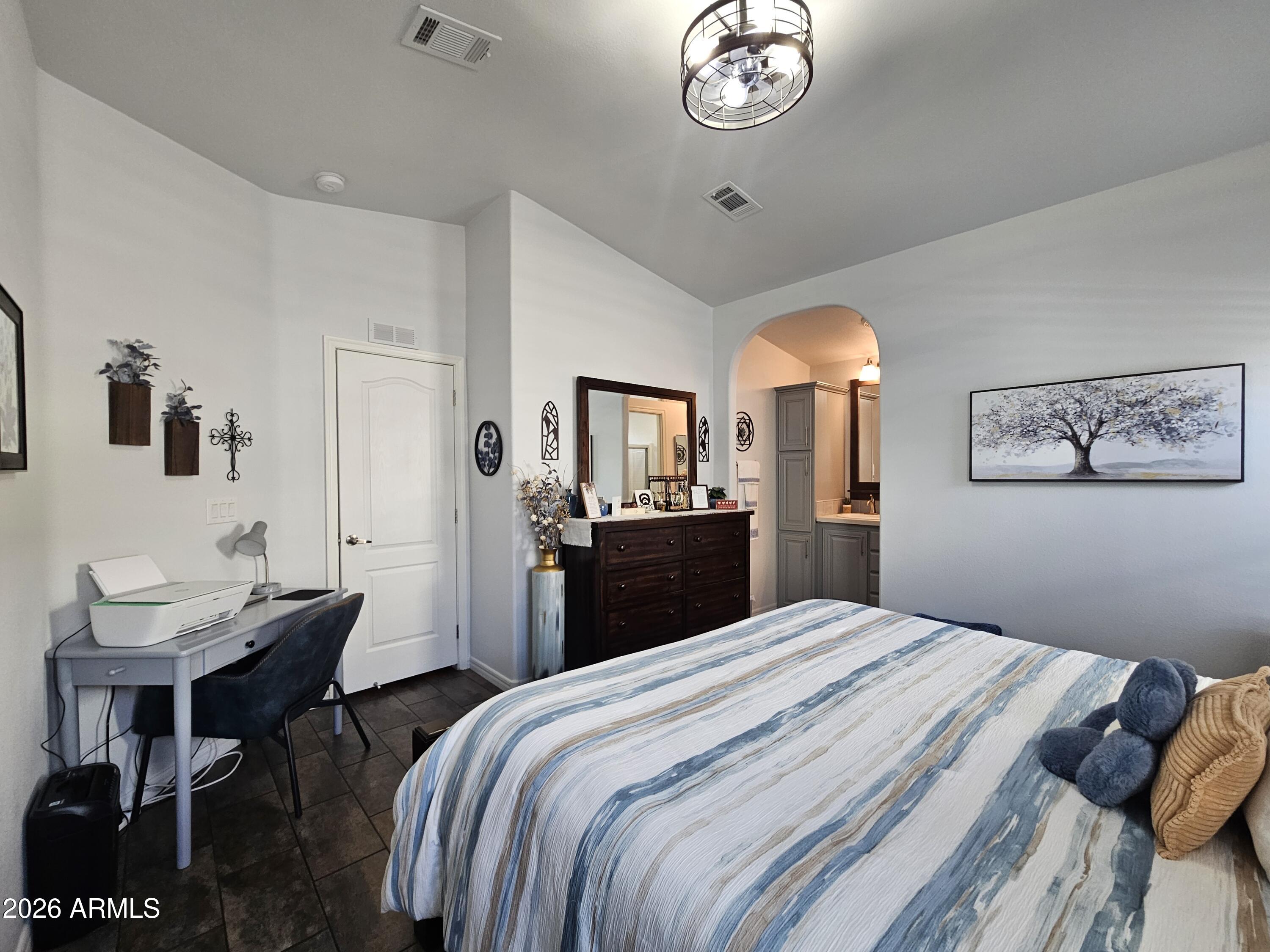 650 North Hawes Road, Unit 3406 Mesa, AZ 85207 - Photo 27 of 45 a bedroom with a bed and a chandelier